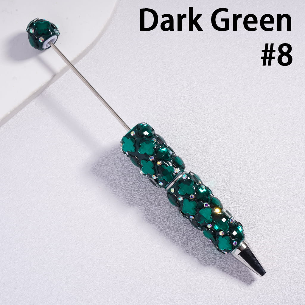 Dark green beaded pen on a white background