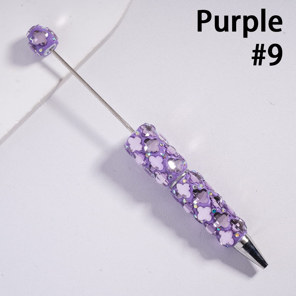 Purple decorative pen with floral design on a white background