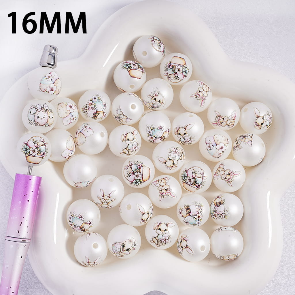 White pearls with floral designs on a white heart-shaped dish, with a pink tool next to it.