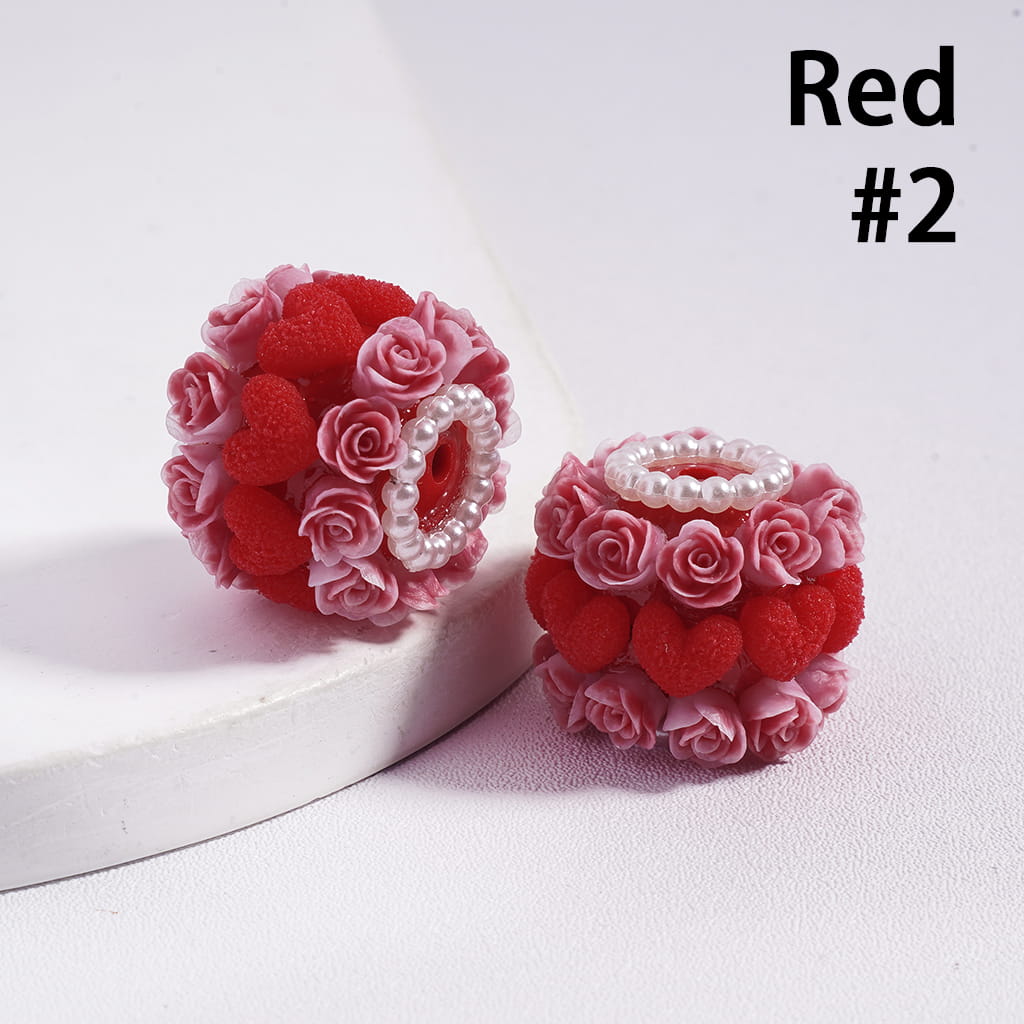 Red and pink floral earrings with pearl accents on a white background