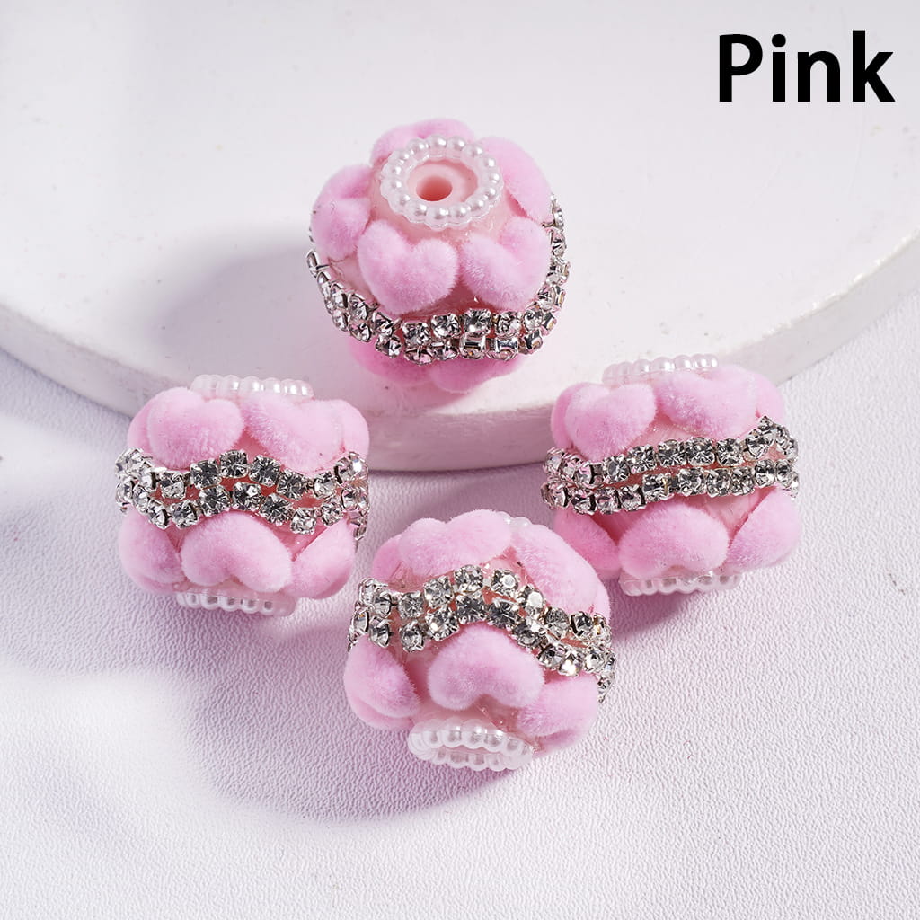 Pink flower-shaped hair accessories with rhinestones on a light pink background