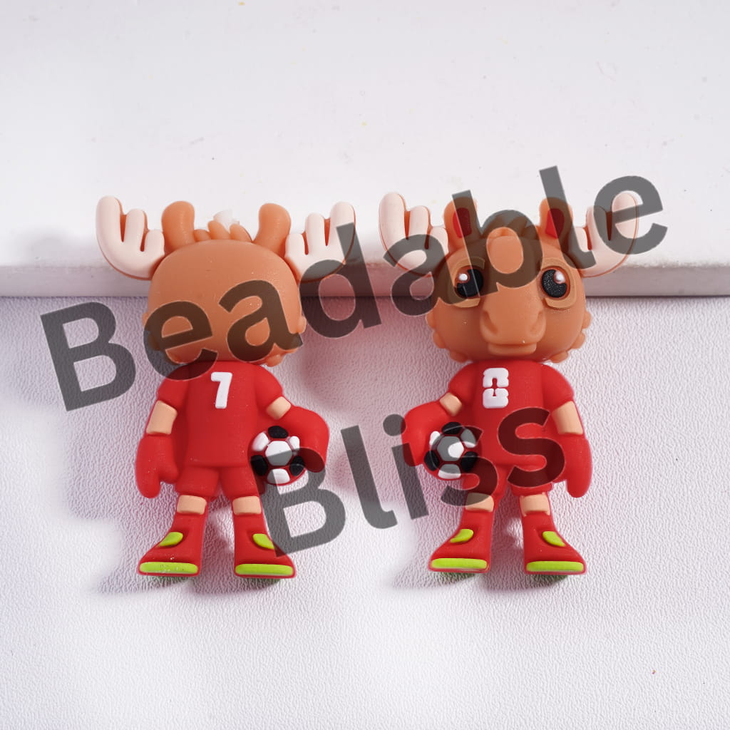 Two moose-shaped figurines wearing red outfits with green shoes on a white background, branded 'Beadable Bliss'.