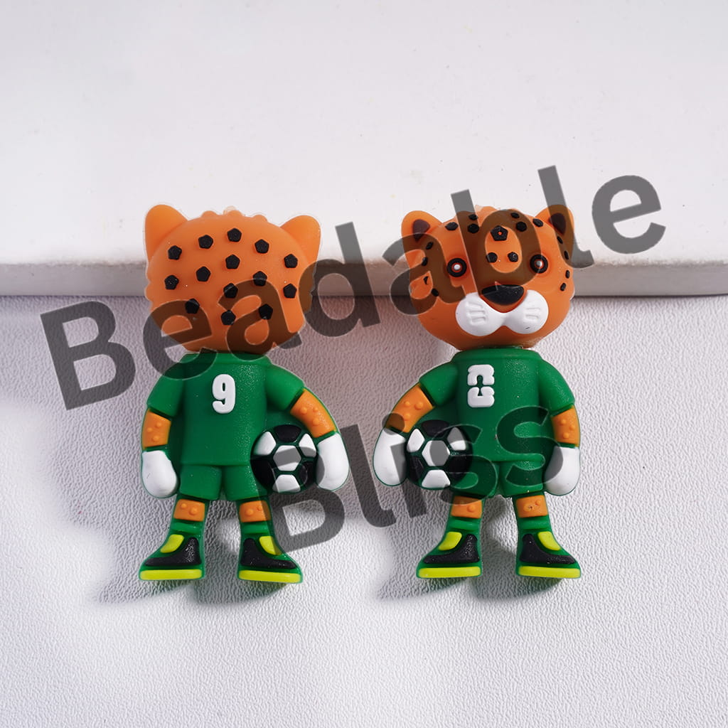 Two tiger-shaped earrings with green outfits and numbers on a white background.