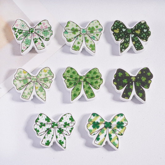 Set of green bow-shaped hair clips with shamrock patterns on a white background