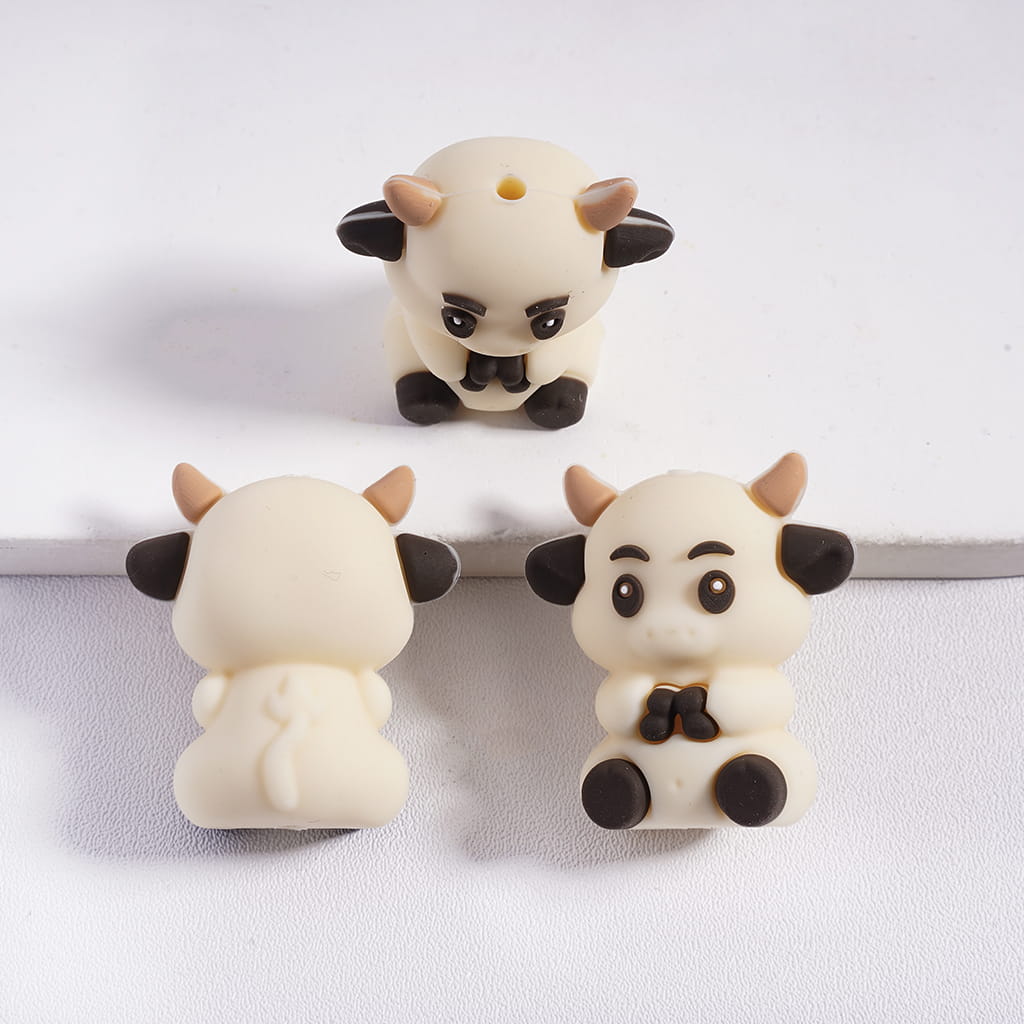 Three small cow figurines on a white background