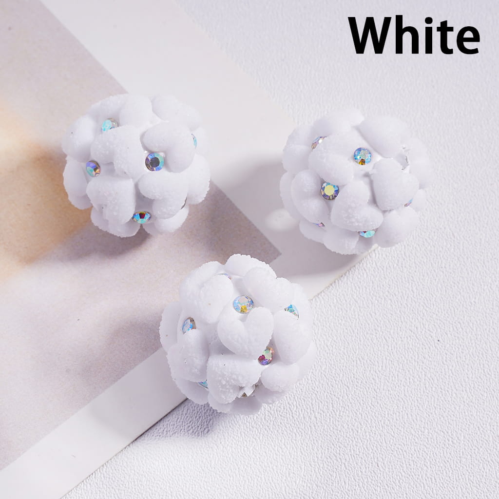 White floral earrings with rhinestones on a light background