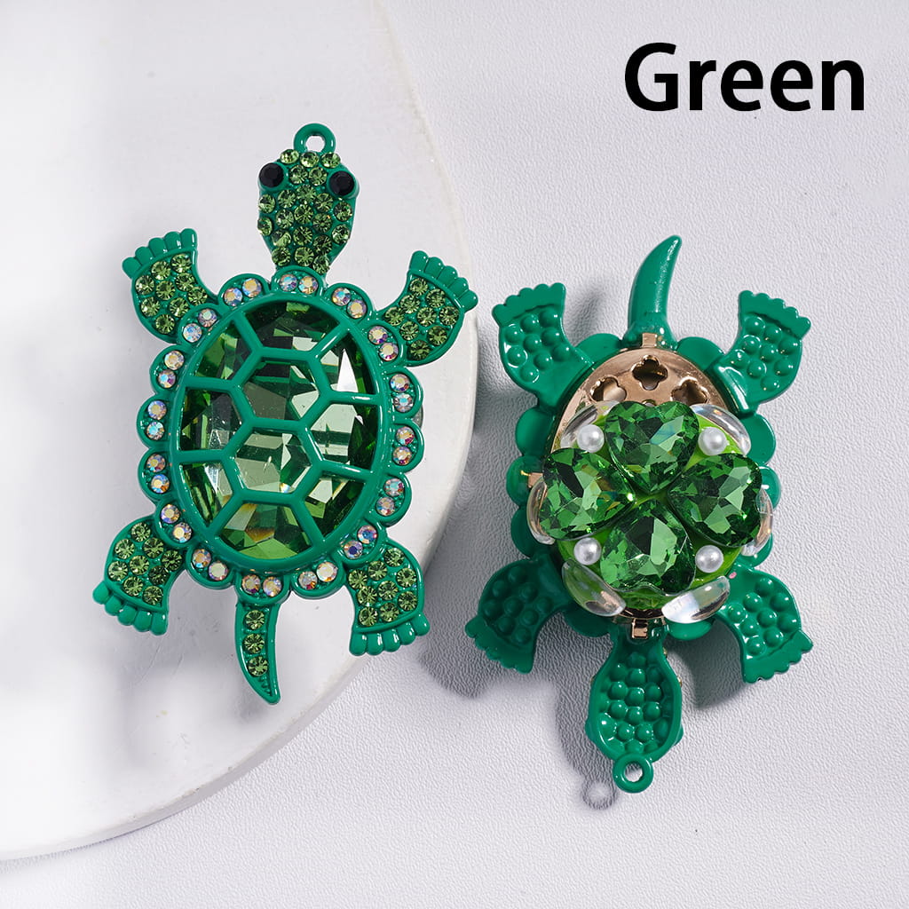 Green turtle-shaped earrings with gemstones on a white background