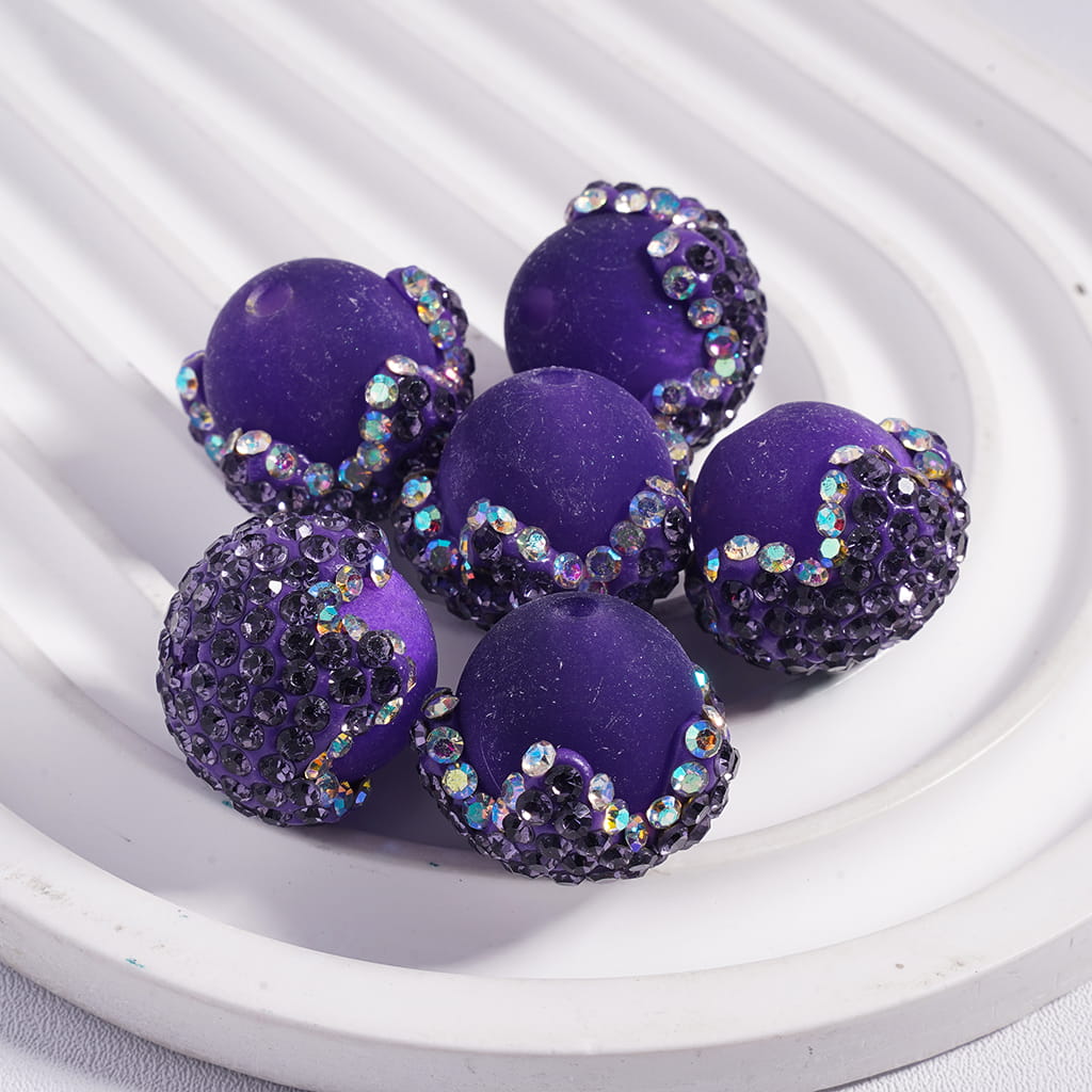 Purple beads with glittery accents on a white surface