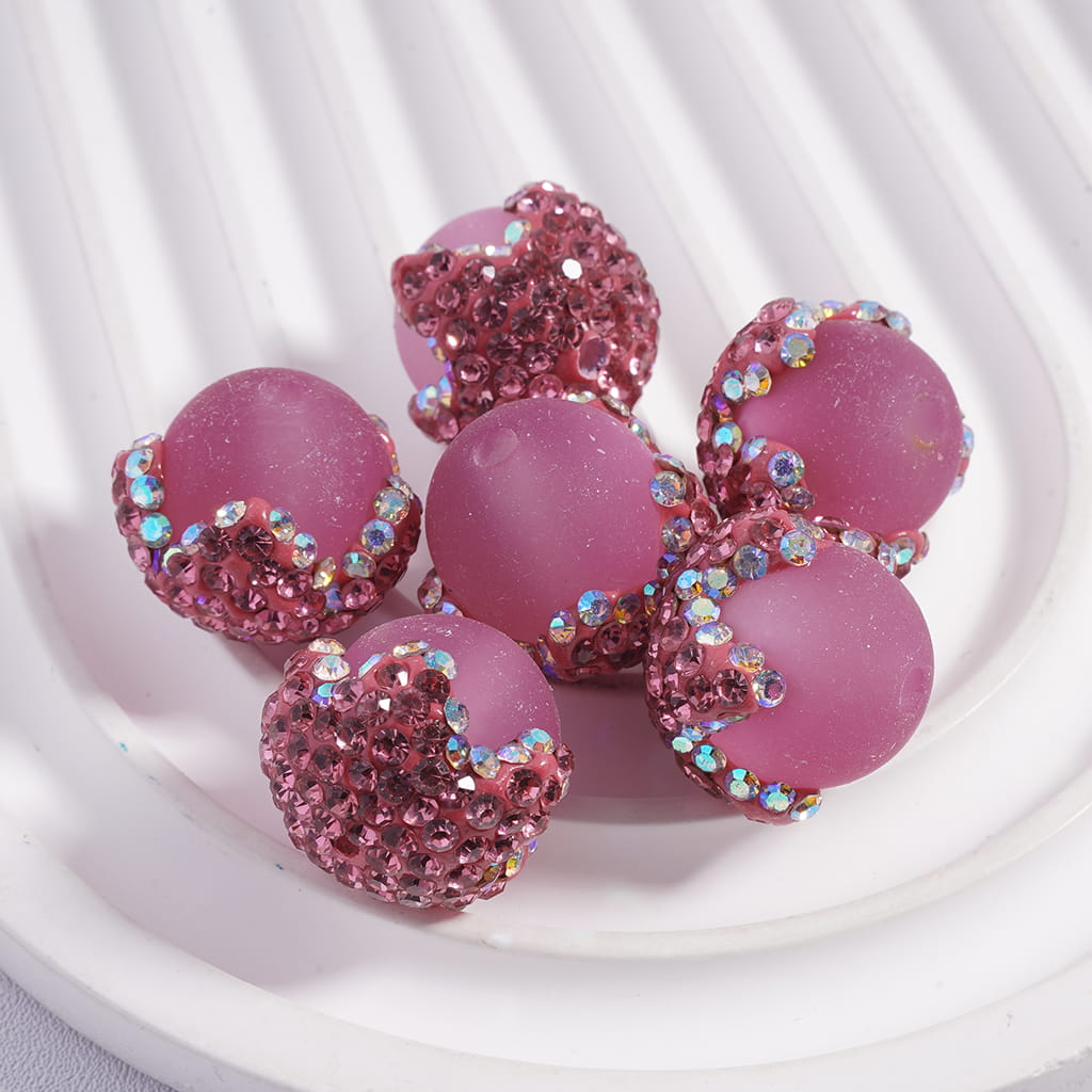 Pink earrings with gemstone accents on a white background