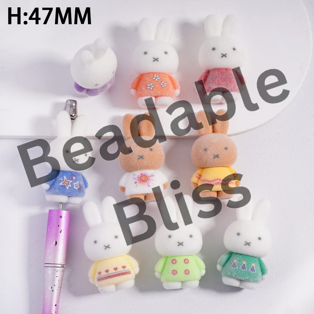 Set of small rabbit-shaped desk organizers on a desk with a laptop.