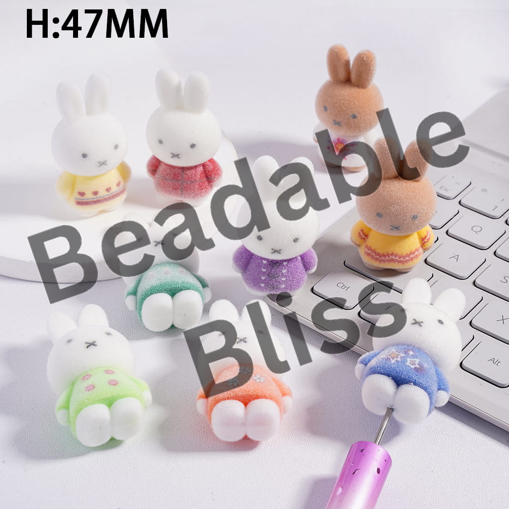 Set of small rabbit-shaped desk organizers on a desk with a laptop.