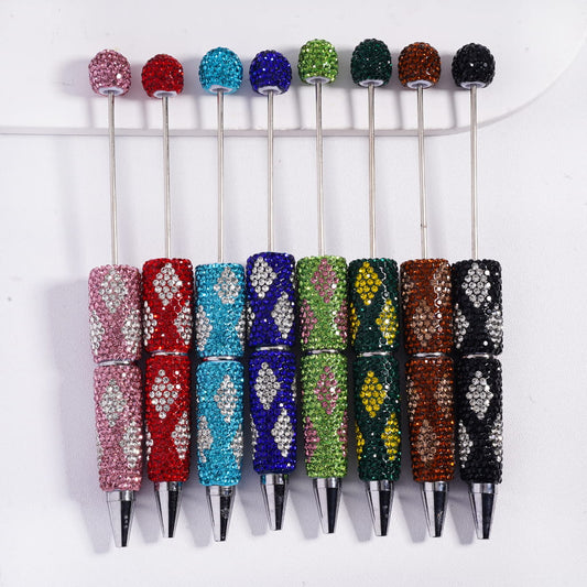 Five decorative pens with colorful gemstones on a white background