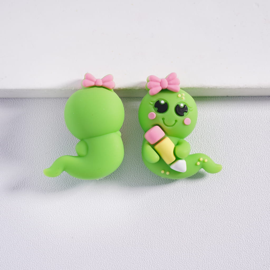 Two green cartoon-style characters with pink bows on a white background