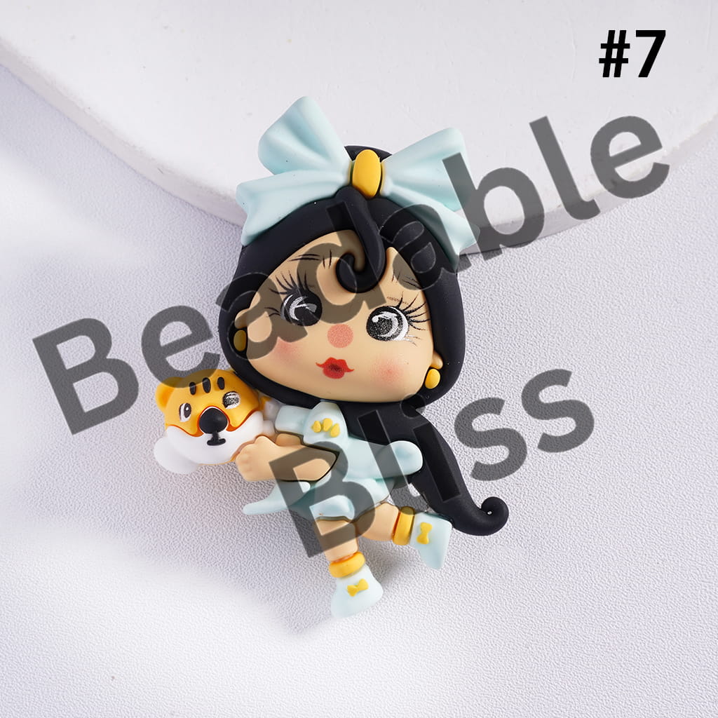 Cartoon character figurine with a bow and a small animal, branded 'handsonsupply'.