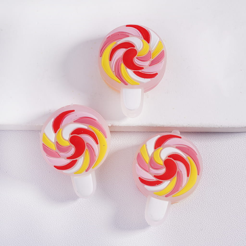 Three colorful lollipop-shaped phone holders on a white background
