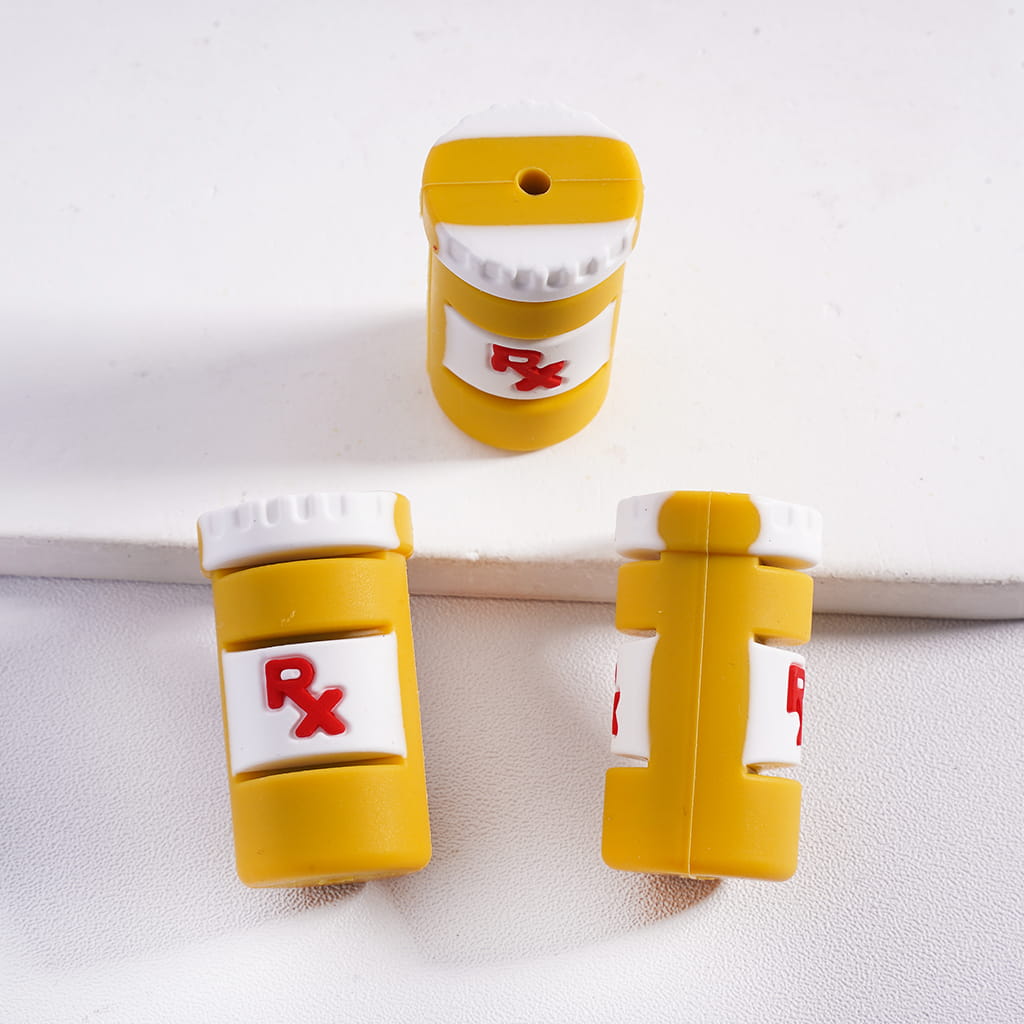 Yellow pill bottle-shaped clips with white caps on a white background