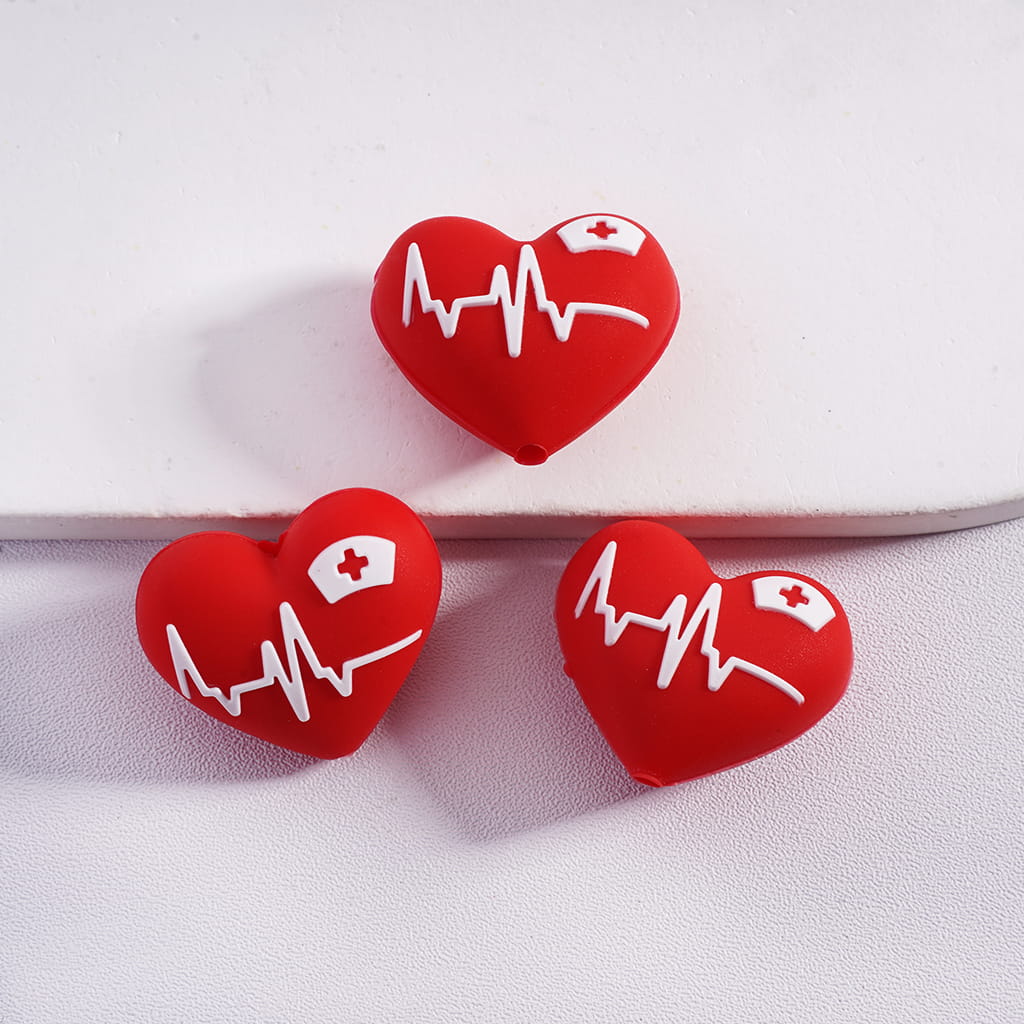 Red heart-shaped earrings with medical symbols on a white background