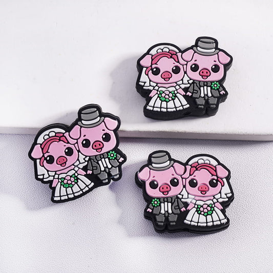 Two cartoon pig wedding magnets on a white surface