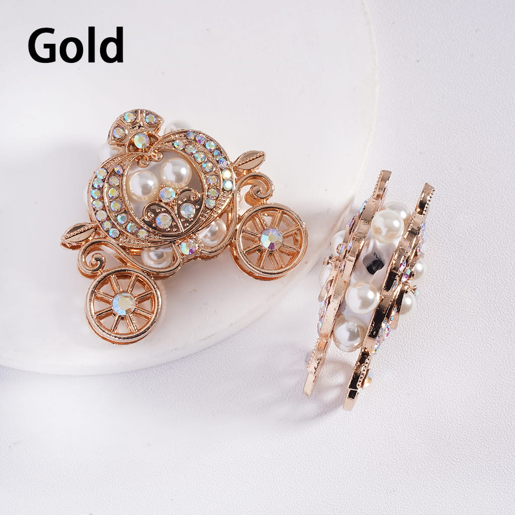 Gold carriage-shaped brooch with pearls on a white background
