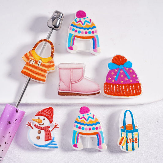 Colorful cookie cutters shaped like winter-themed items on a white background