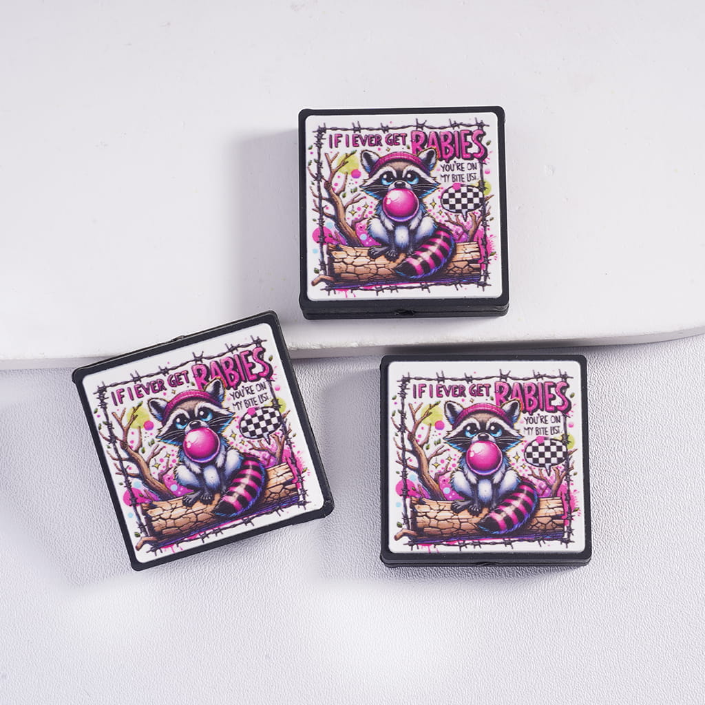 Three colorful coasters with a raccoon design and text on a white surface.