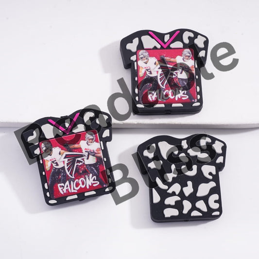 Three decorative pins with 'Falcons' branding on a white background