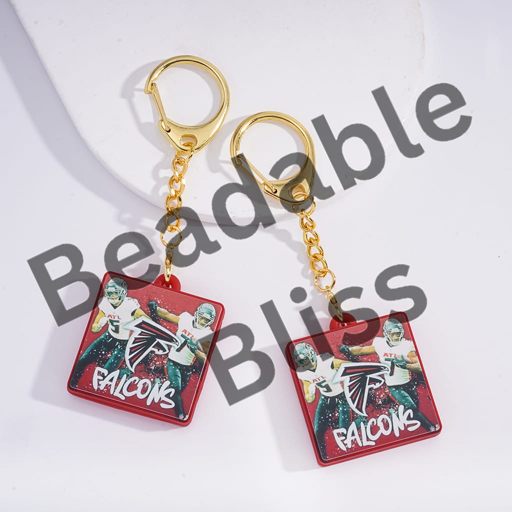 Two keychains with a sports team logo on a white background, branded 'handsonsupply.com'.