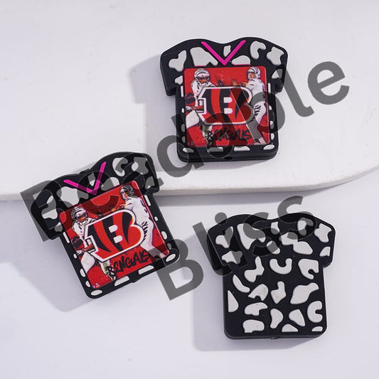 Three decorative items shaped like sports jerseys with logos on a white background.