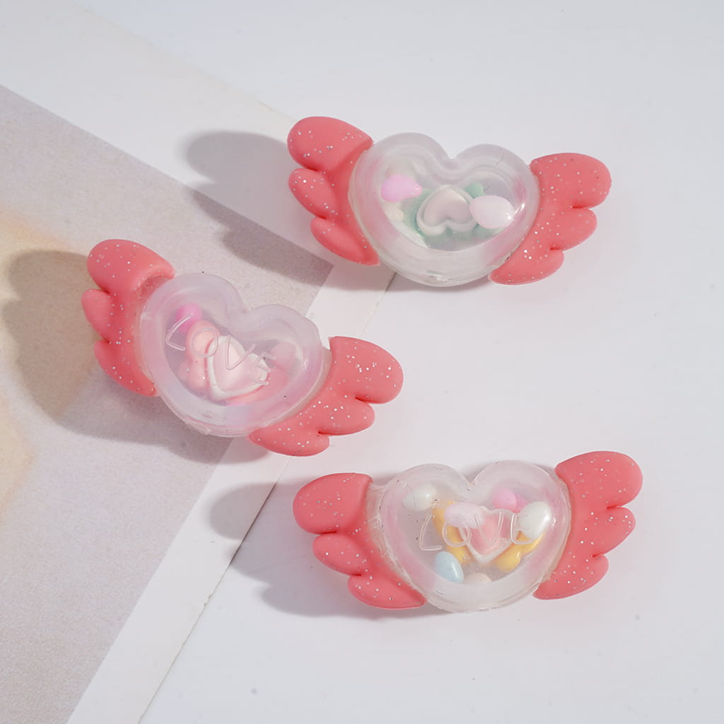 Heart-shaped clips with pink wings on a white background