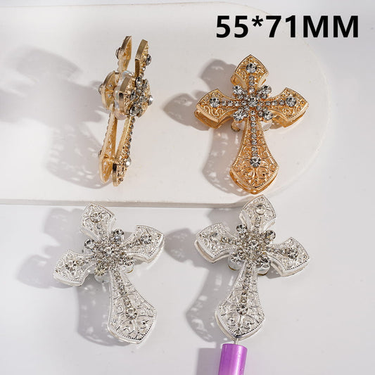 Pair of cross-shaped earrings with gold and silver colors on a white background.