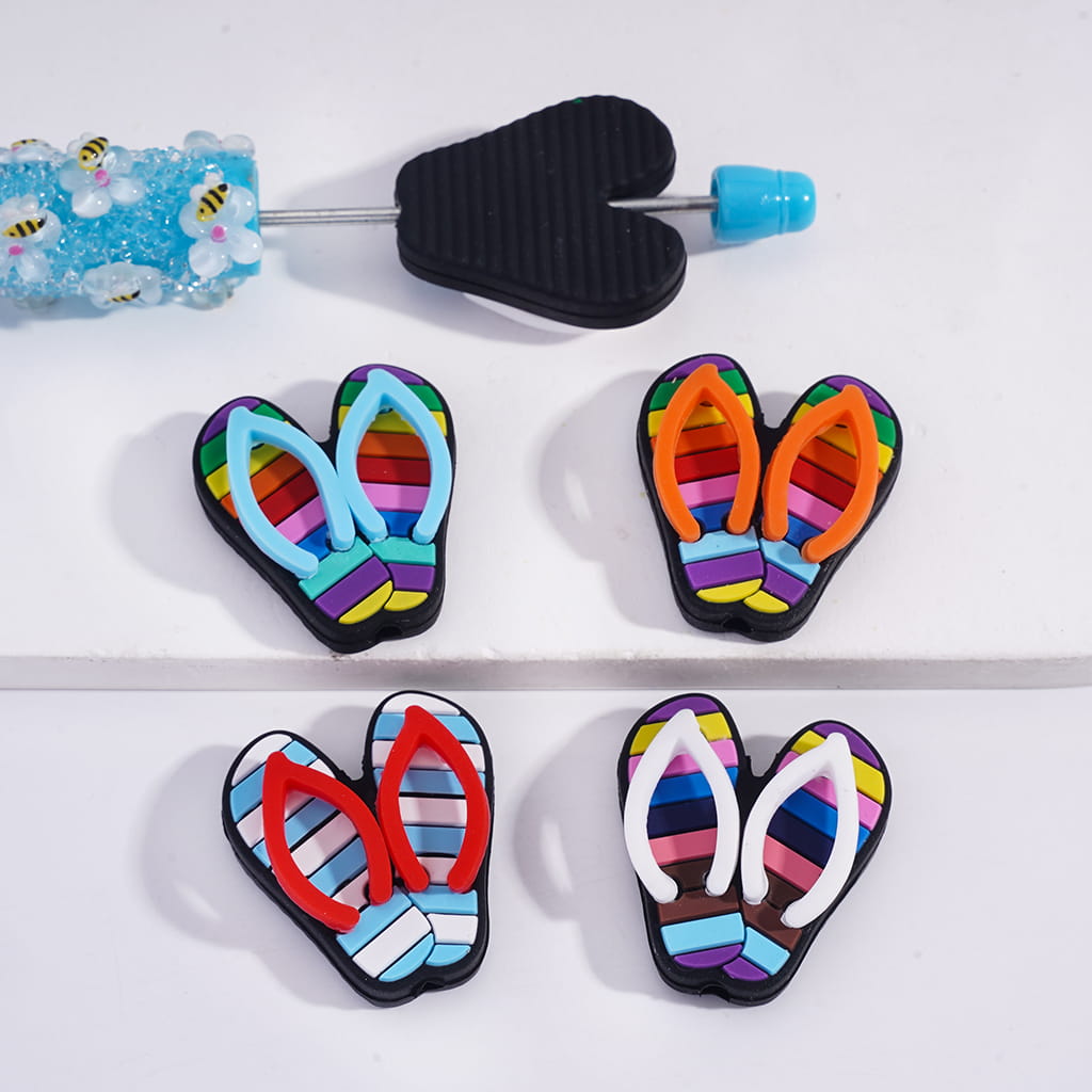 Colorful flip-flop-shaped cookie cutters on a white surface
