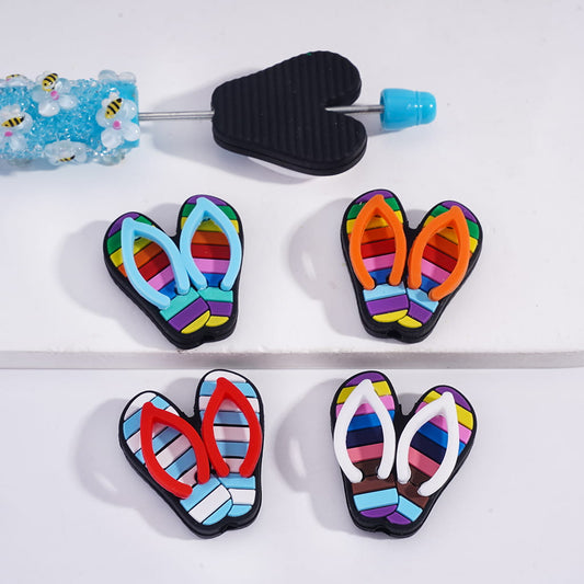 Colorful flip-flop-shaped cookie cutters on a white surface