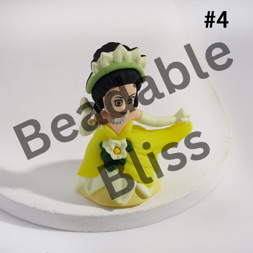 Small figurine of a character in a yellow dress with a green hat on a white background, branded 'handmade supply'.