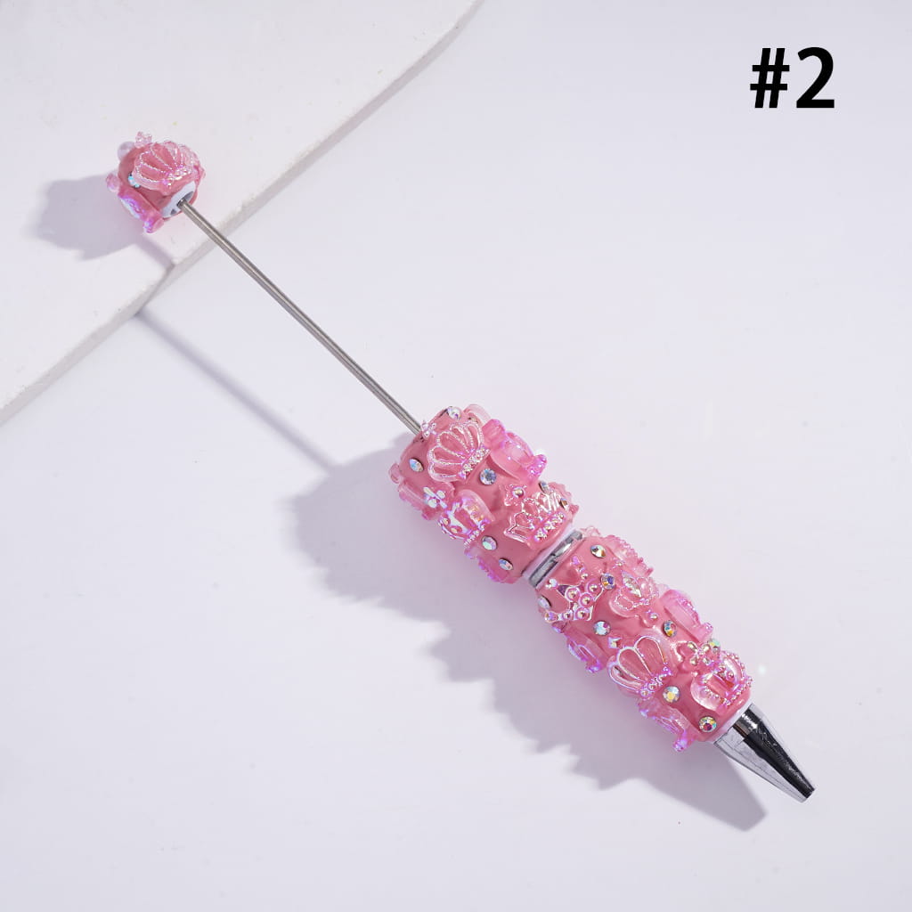 Decorative pink pen with floral designs on a light gray background