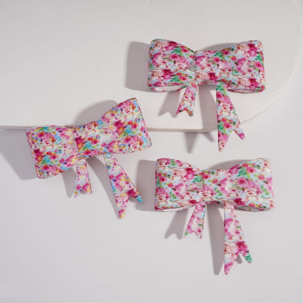 Three floral-patterned hair bows on a white background