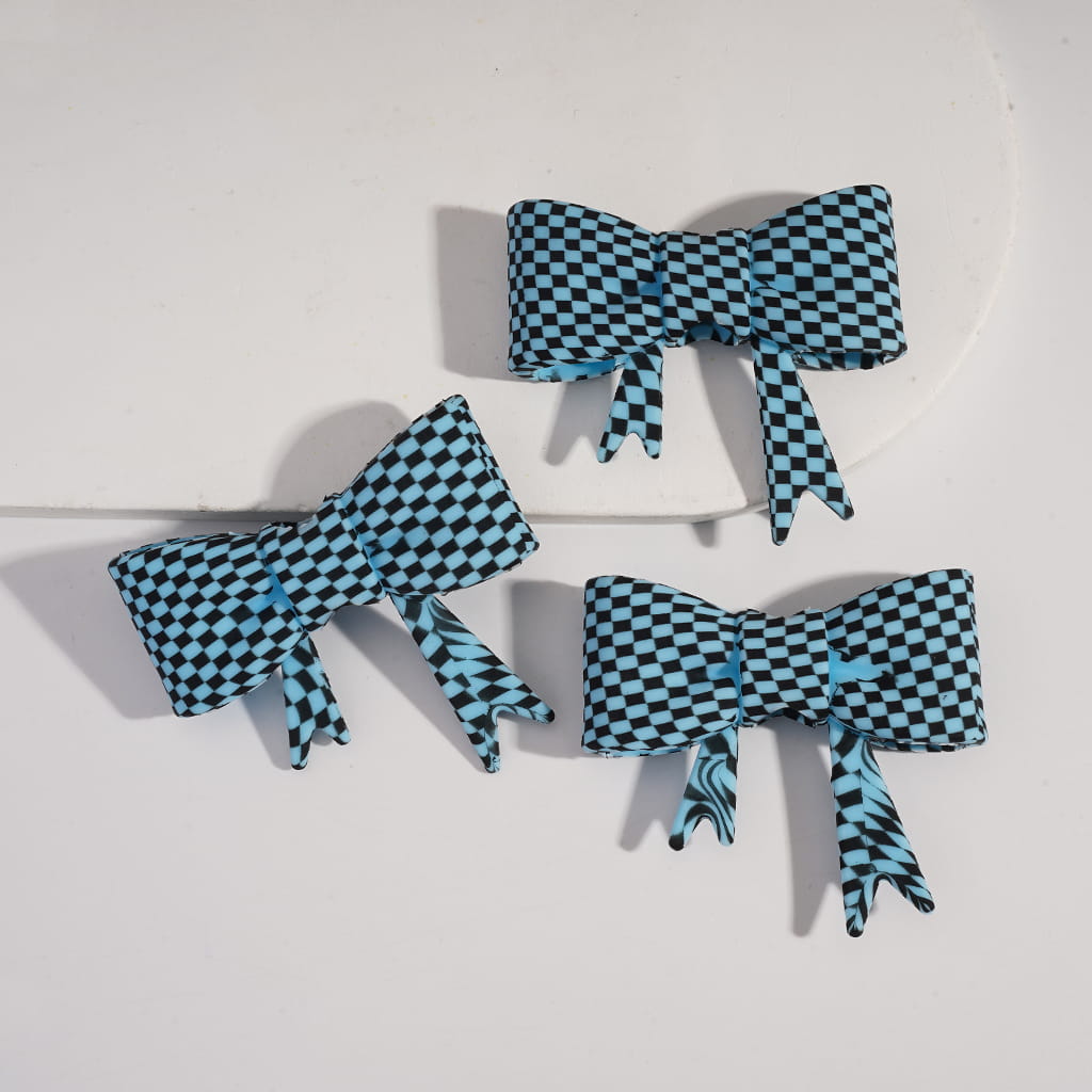Three blue and black checkered bows on a white background