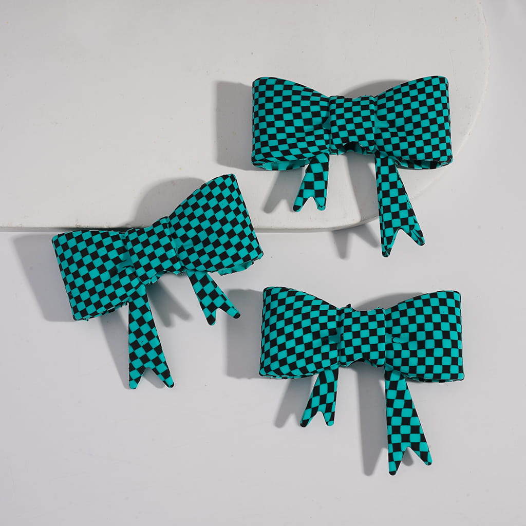 Three green and black checkered bows on a white background