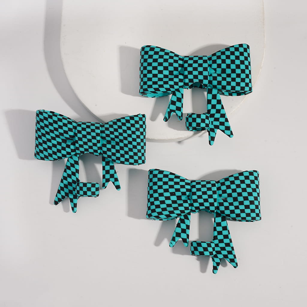 Checkered bow-shaped earrings on a light background