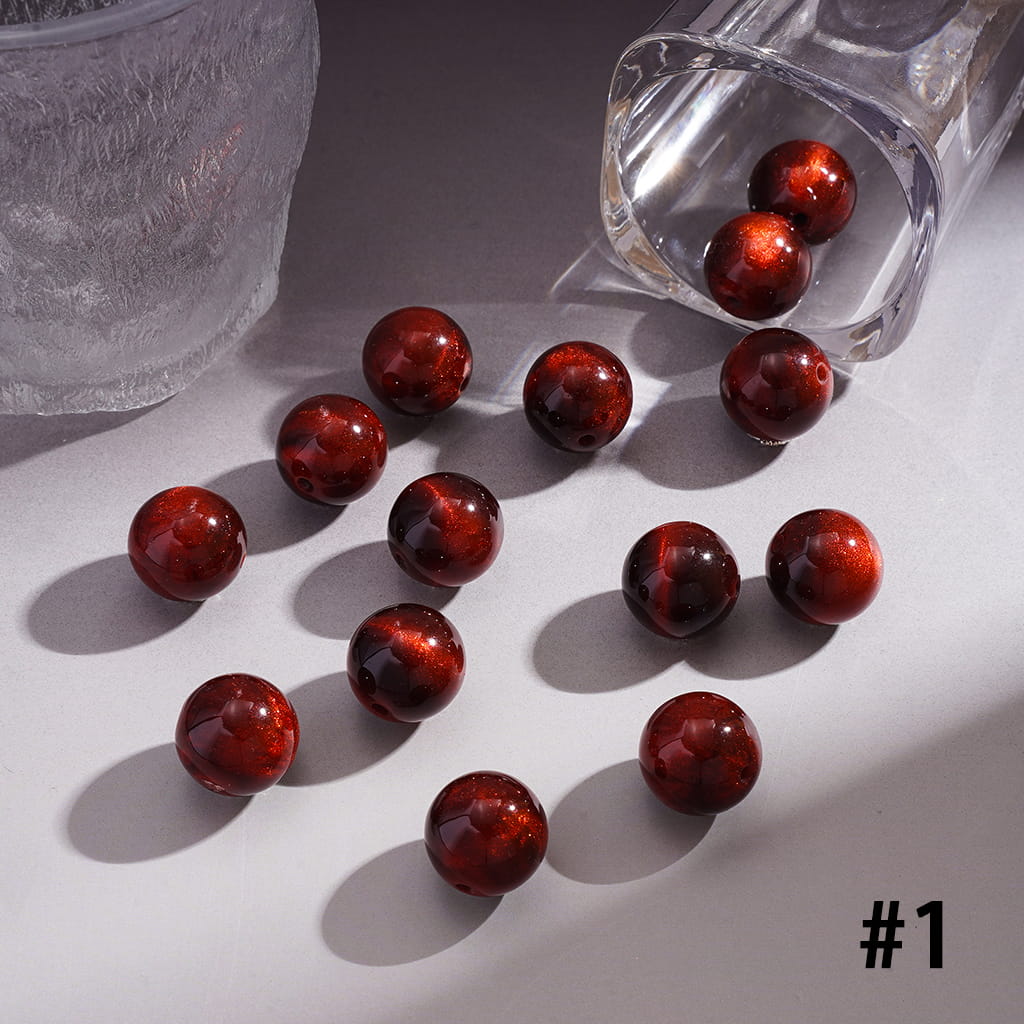 Red marbles spilling from a glass container onto a white surface