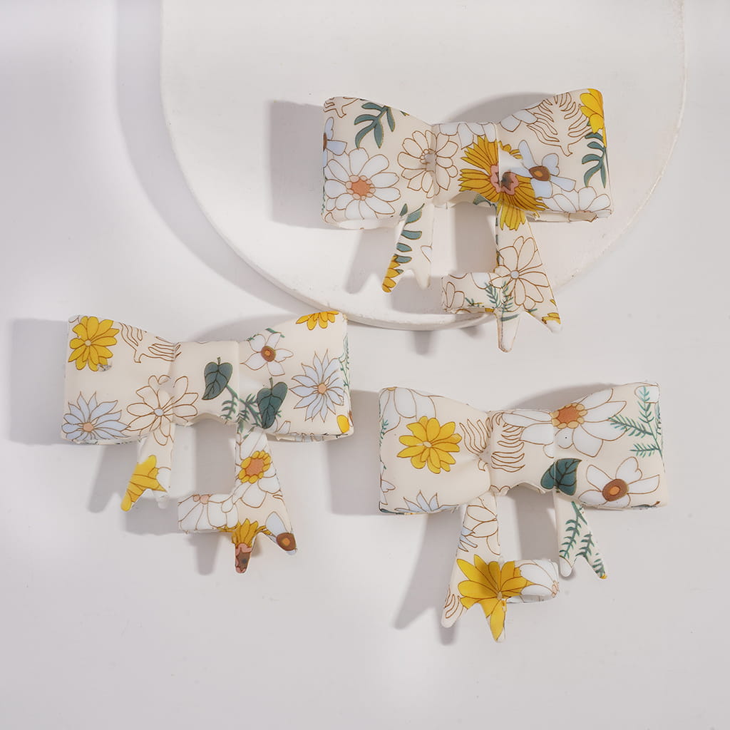 Floral-patterned hair accessories including bows and clips on a white background