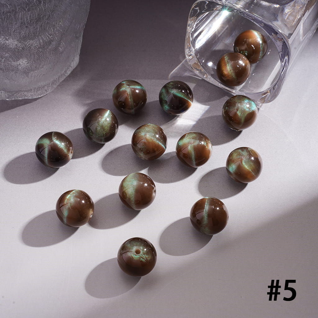 Brown marbled beads on a light surface with a bottle of nail polish.