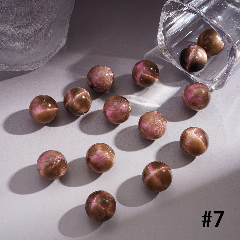 Marbled brown and pink beads on a light surface with a clear container.