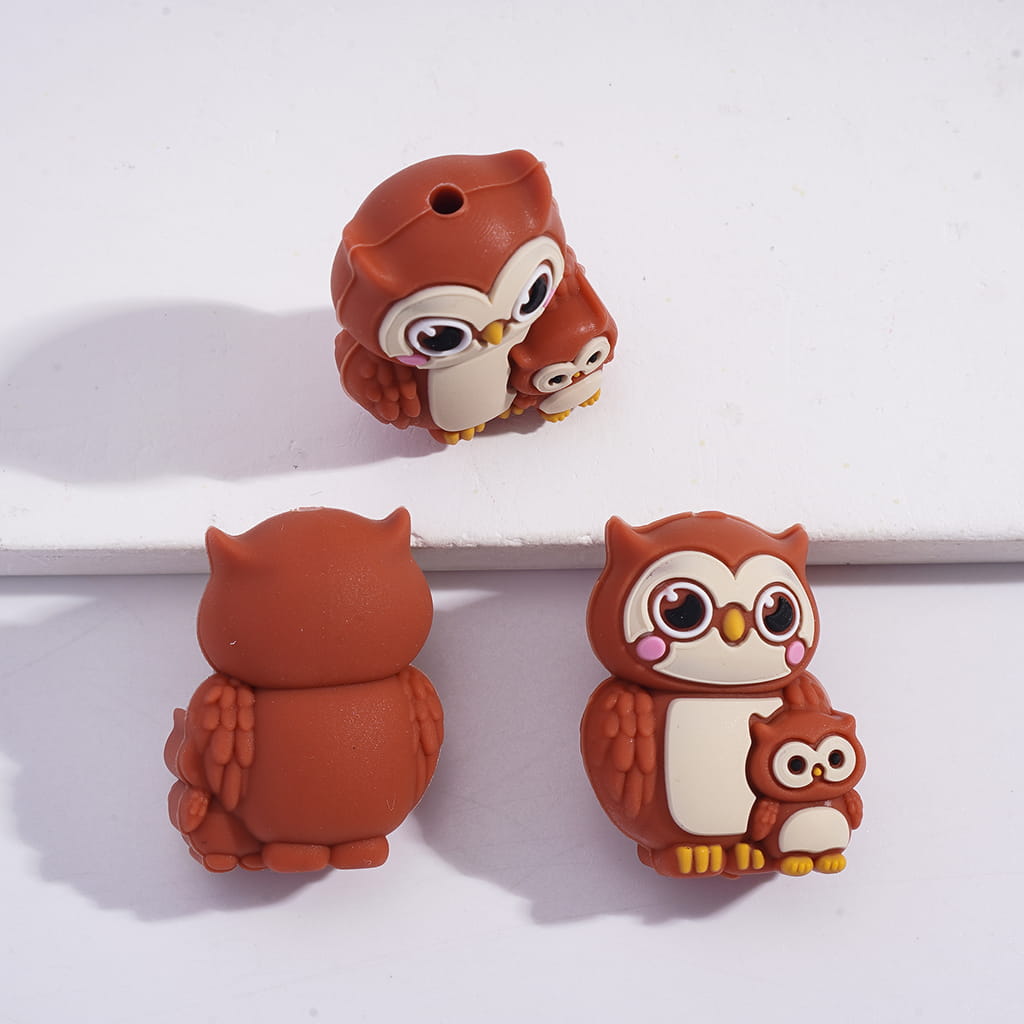 Three brown owl-shaped figurines on a white surface