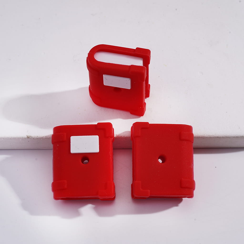 Three red plastic components on a white background