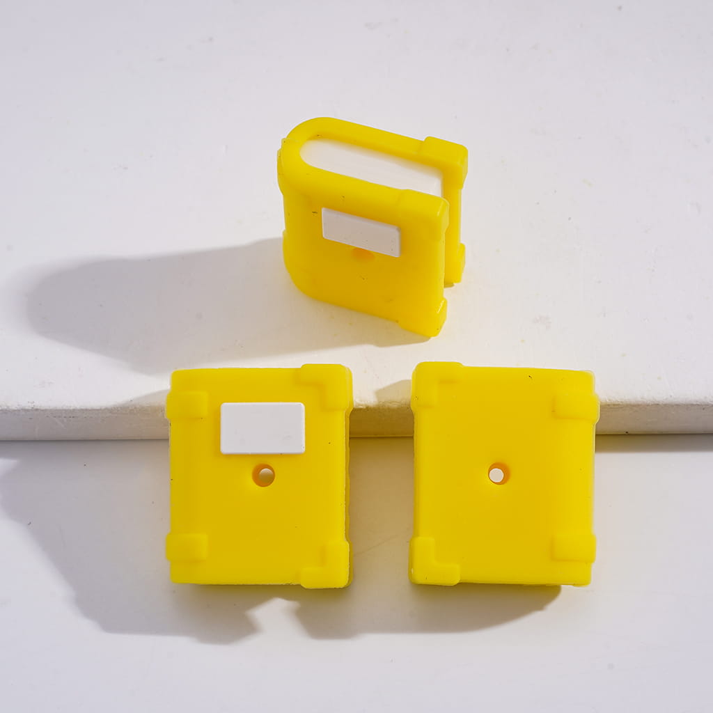 Three yellow plastic clips on a white background