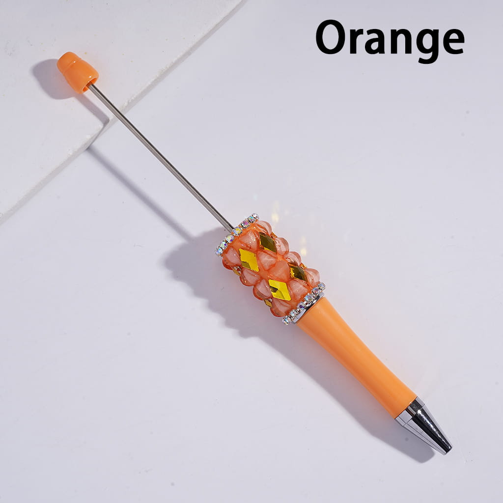 Orange pen with decorative cap on a light gray background