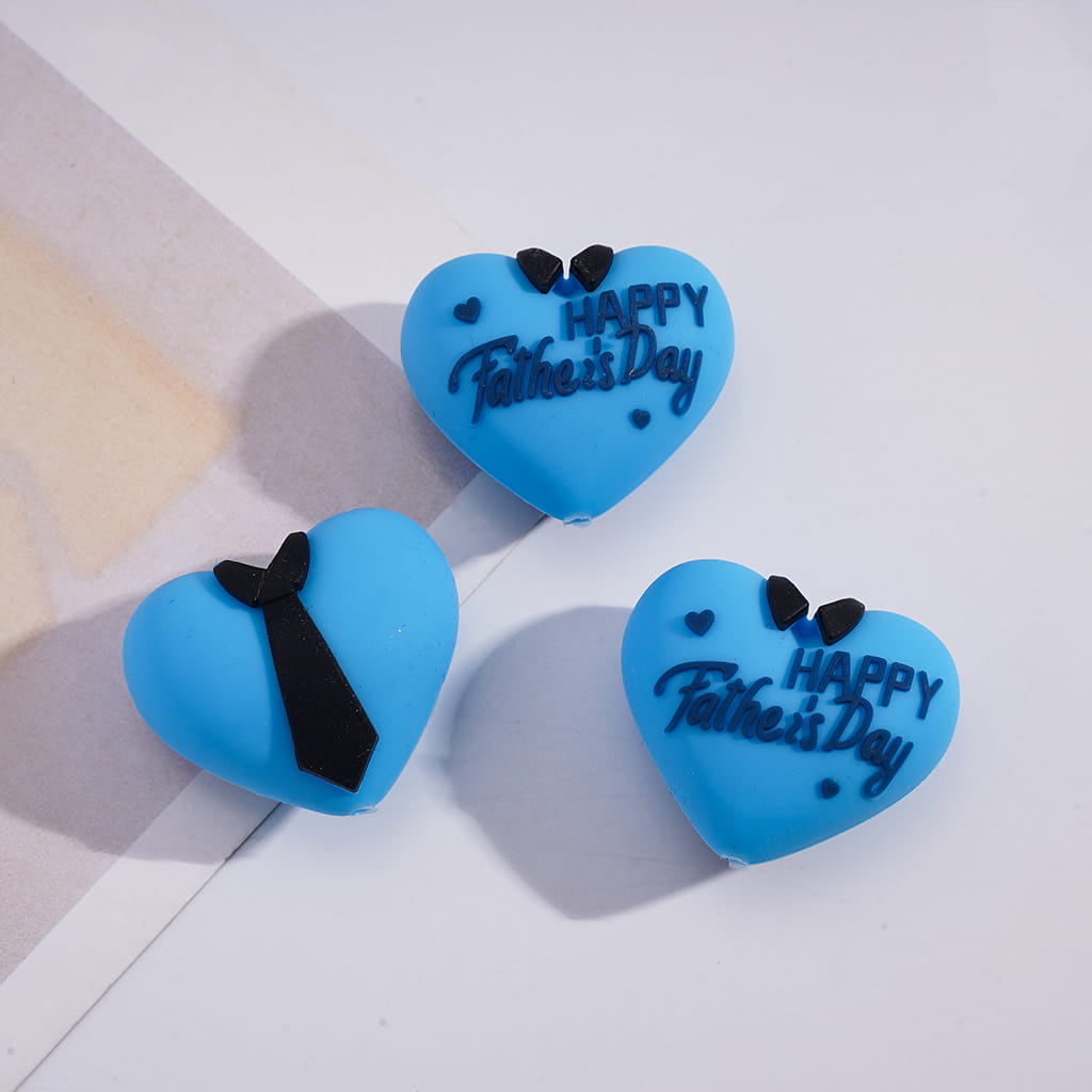 Three blue heart-shaped cookies with 'Happy Father's Day' text and black ties on a light background.