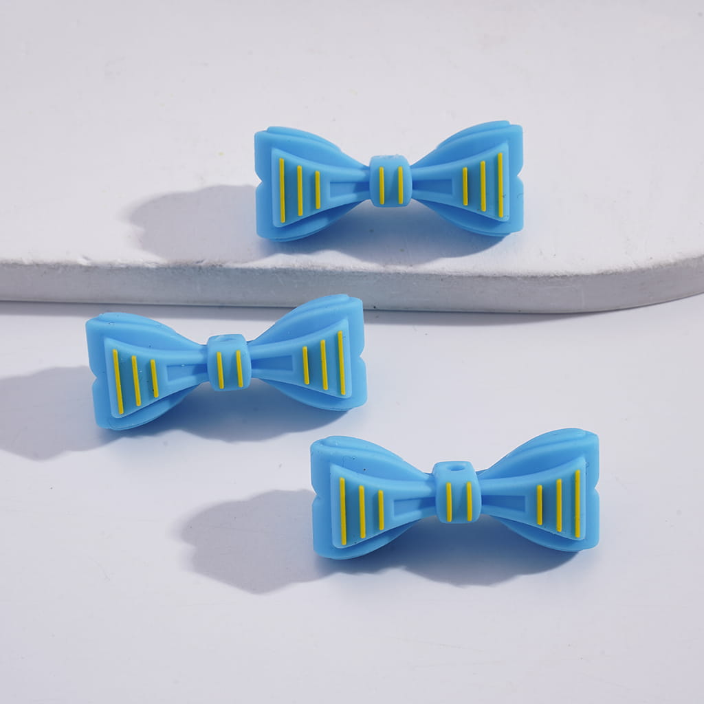 Three blue bow-shaped hair clips with yellow stripes on a white background