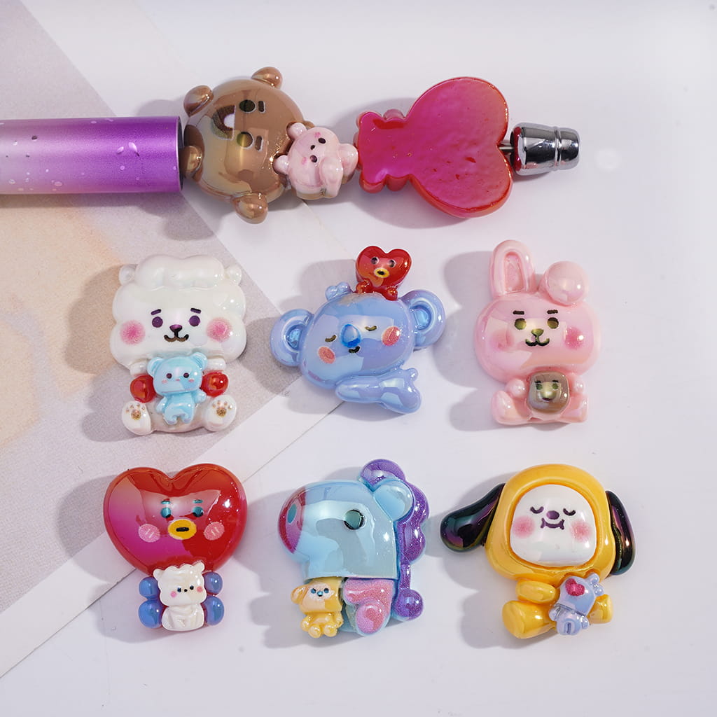 Collection of colorful cartoon character charms on a white background

