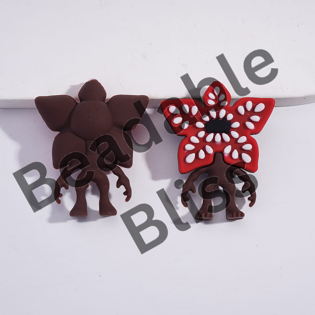 Pair of earrings with brown and red floral designs on a white background.